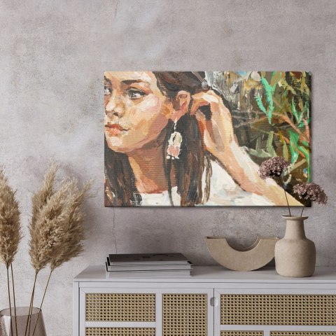 Obraz Na Płótnie A Young Girl Is Sitting In An Ethnic White Dress. The Background Depicts An Autumn Field With Flowers And Herbs