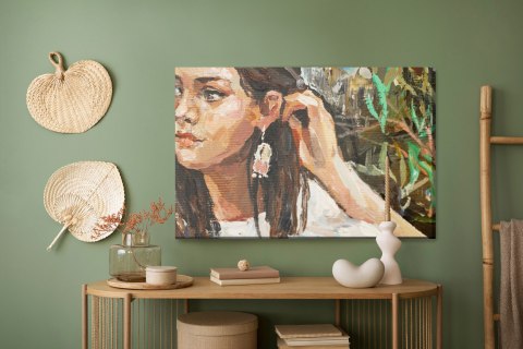 Obraz Na Płótnie A Young Girl Is Sitting In An Ethnic White Dress. The Background Depicts An Autumn Field With Flowers And Herbs