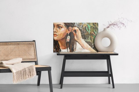 Obraz Na Płótnie A Young Girl Is Sitting In An Ethnic White Dress. The Background Depicts An Autumn Field With Flowers And Herbs